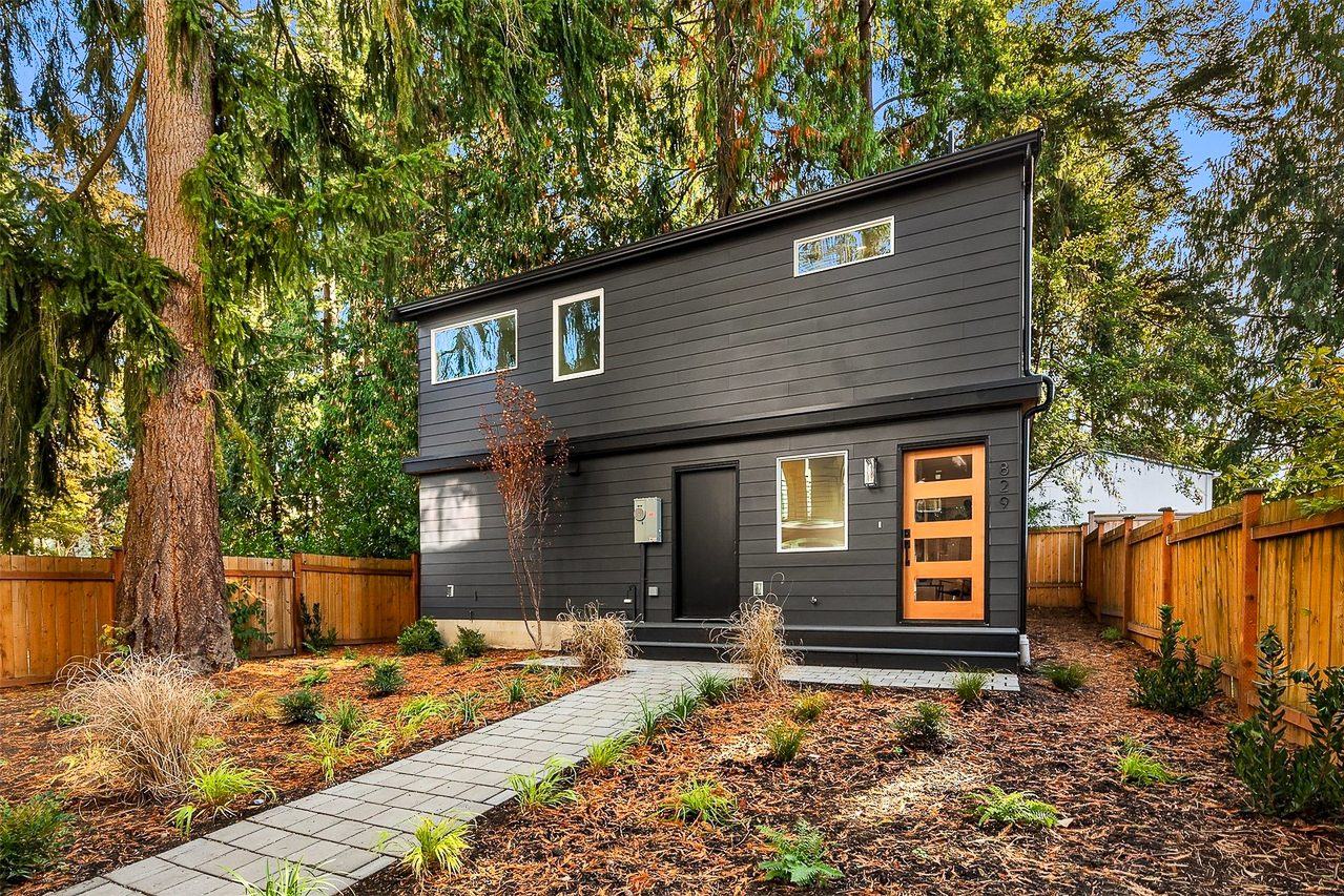 A dark, modern two-level backyard home with wood accents, built in Seattle