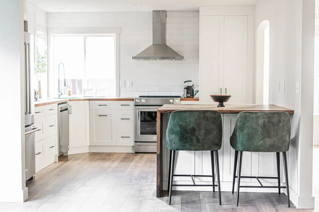 White kitchen with a wood countertop peninsula