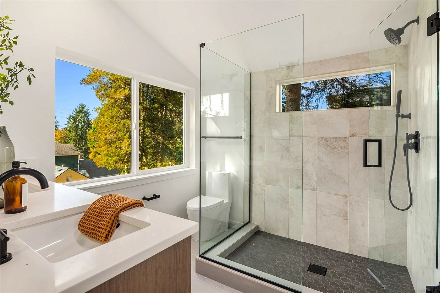 Glass shower with a window and stone tile