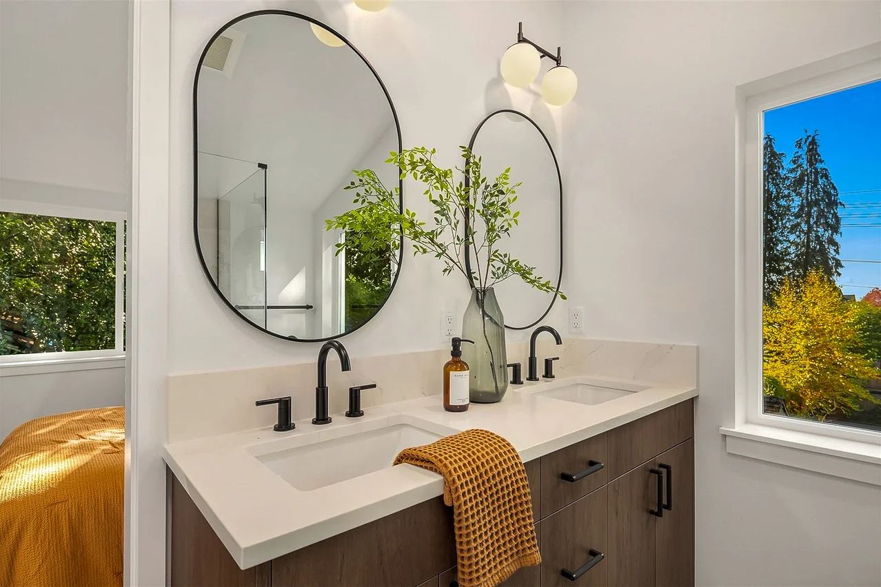 Vanity with a round mirror and a walnut cabinet