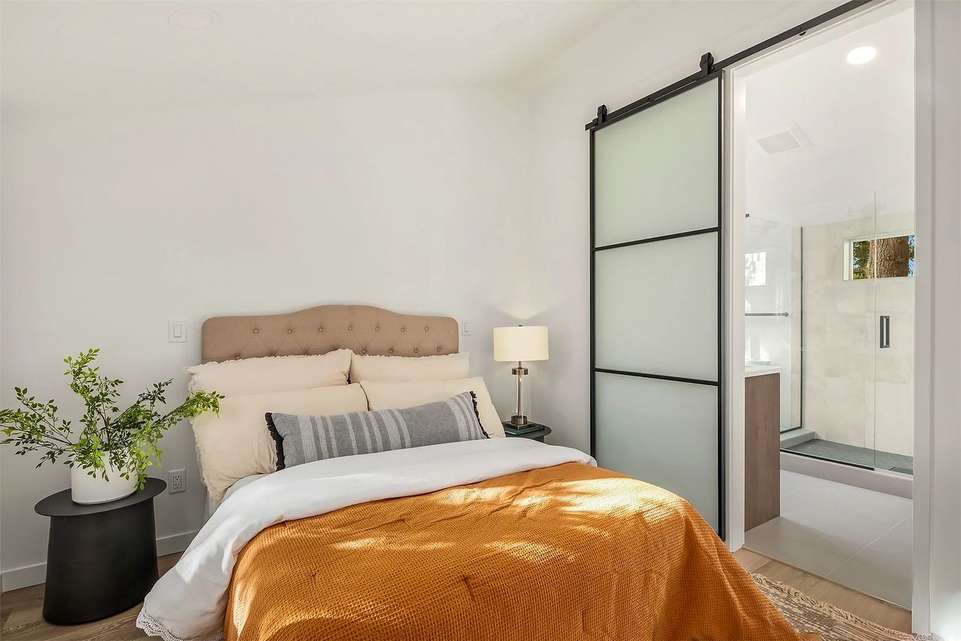 Bedroom with a sliding barn door to the bath