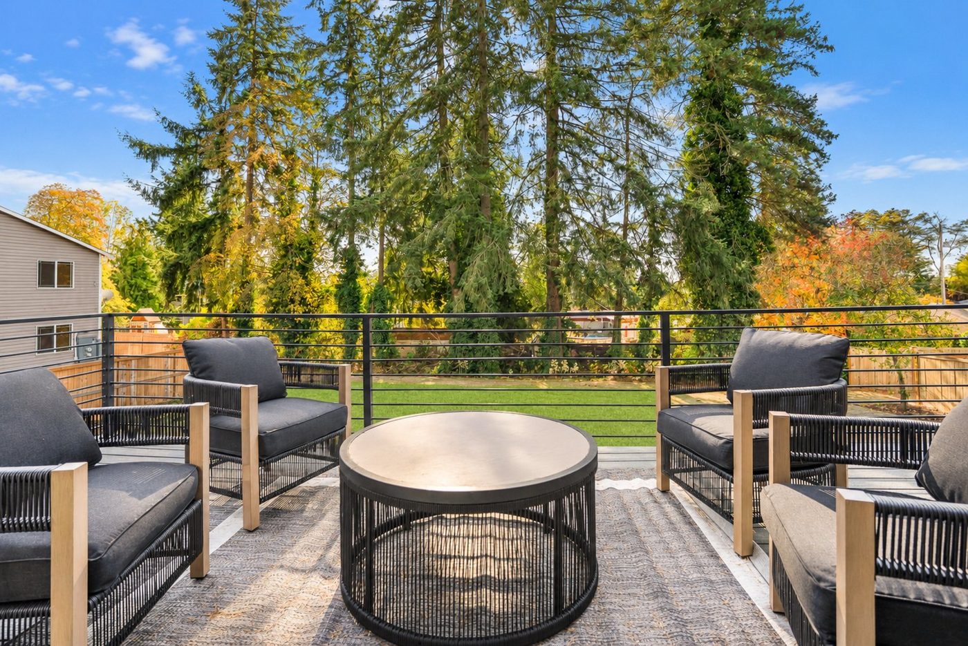 Deck with lounge chairs looking at tall evergreens