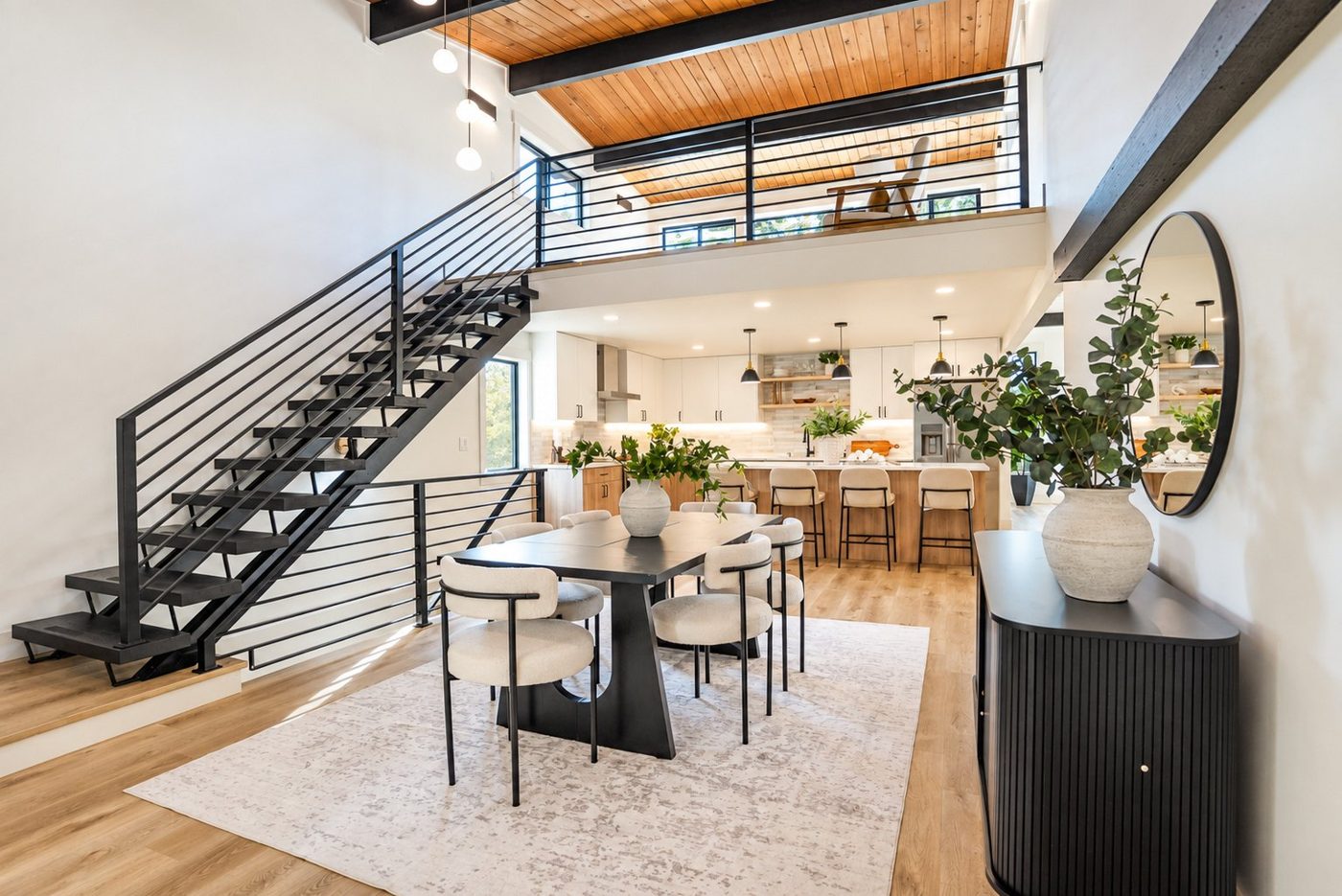 Open living space with a steel stair to a loft and a wood ceiling