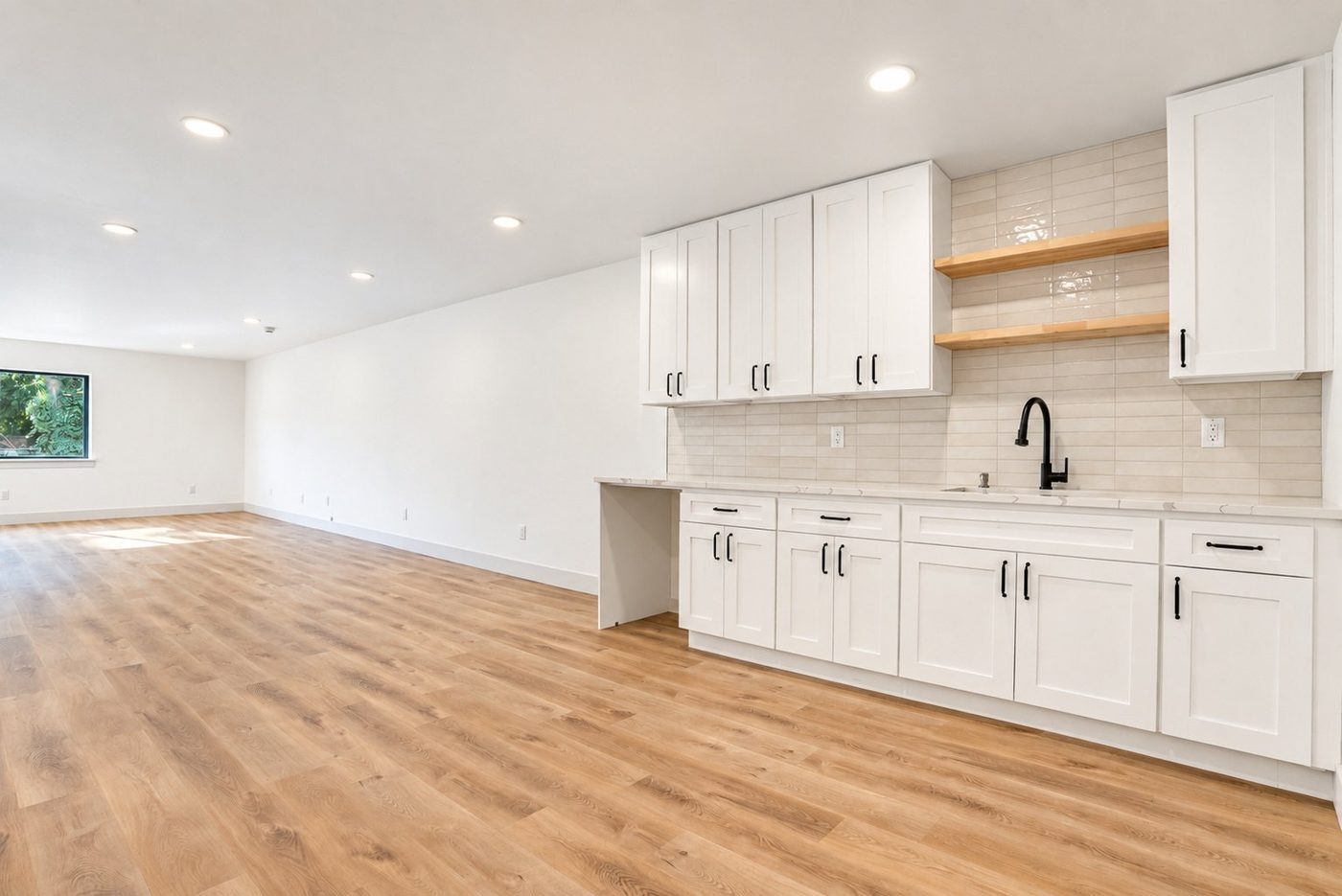 Studio suite kitchenette with white Shaker cabinets and open shelves