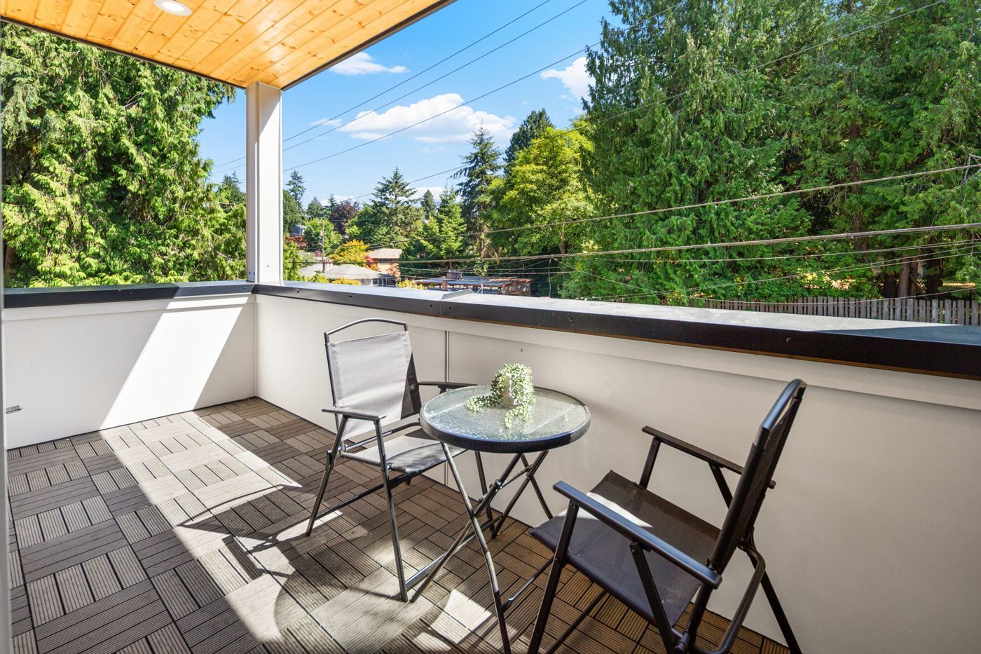Roof deck with a small table and evergreens beyond