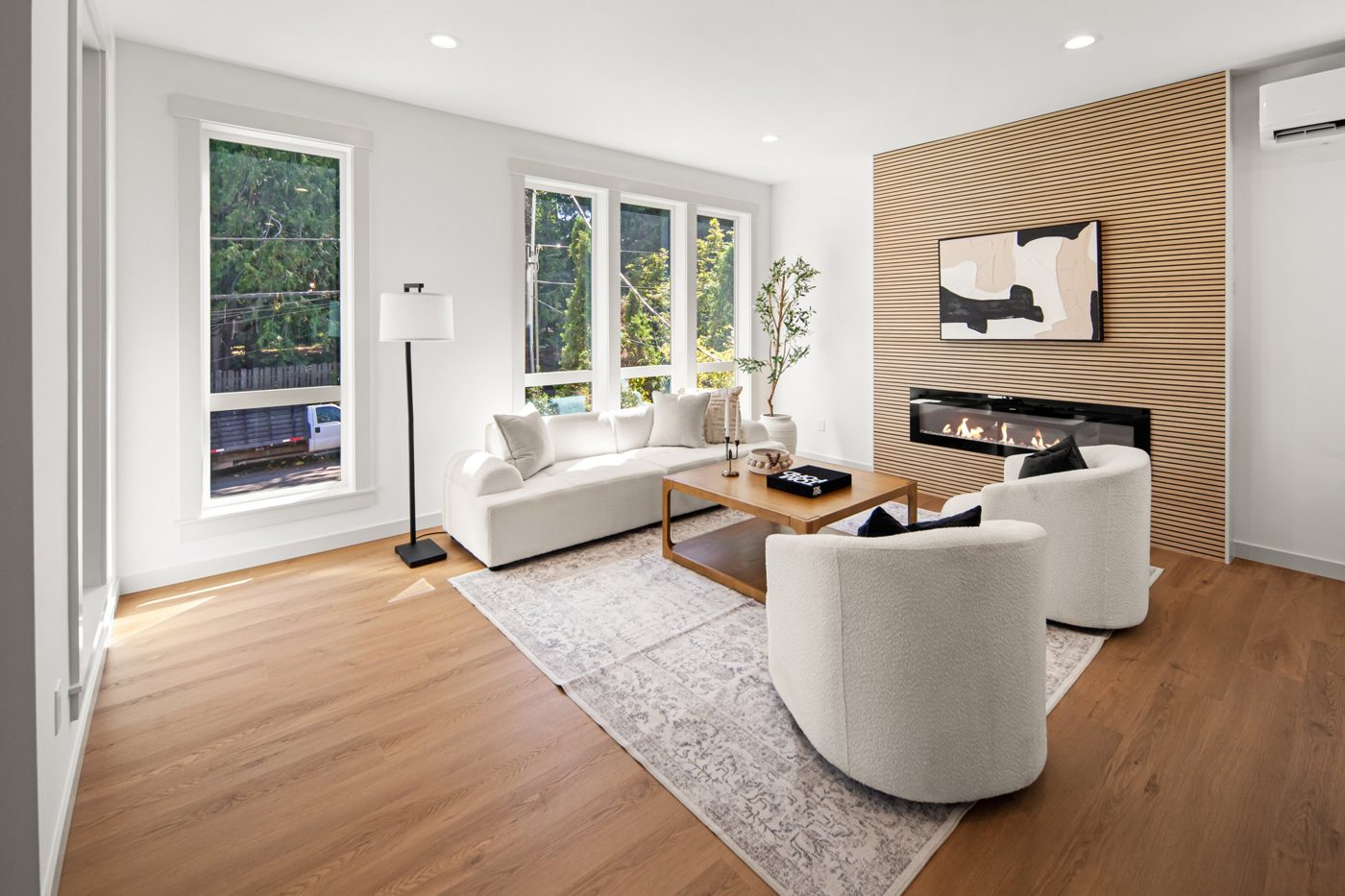 Living room with a wood accent wall and a linear fireplace