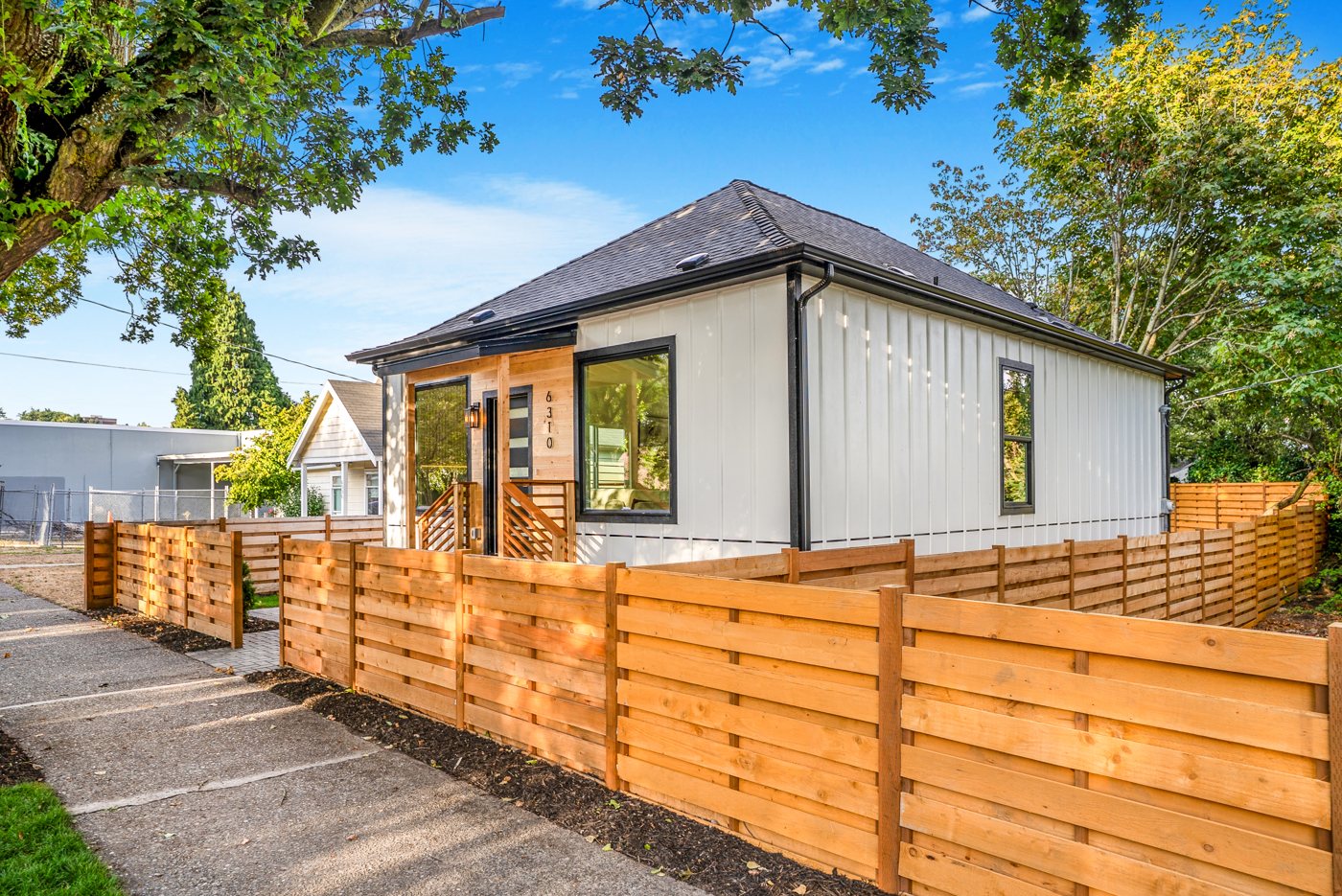 The home from the street corner with the cedar fence
