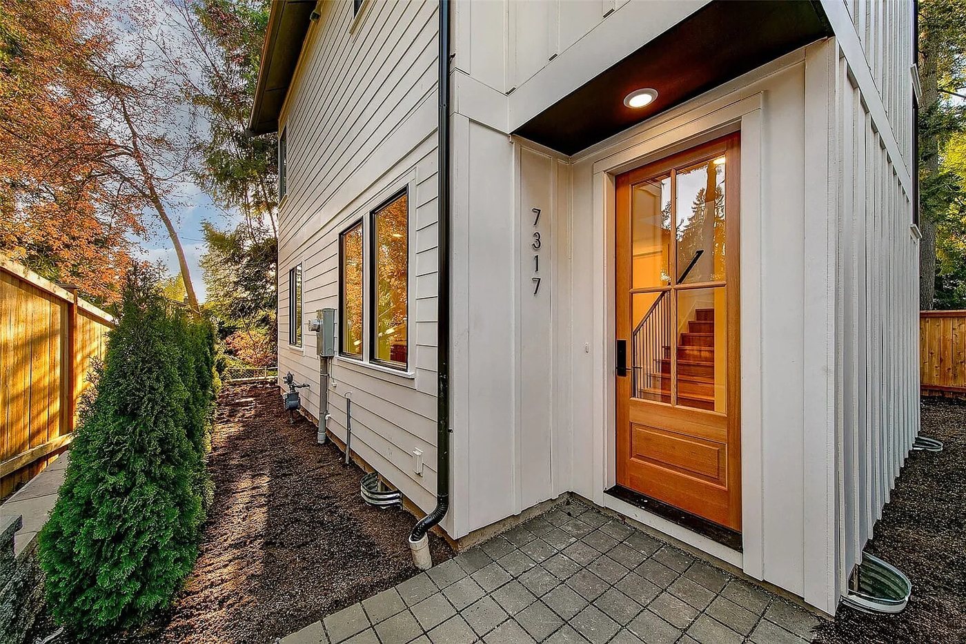 Entry with a wood door and the house number 7317