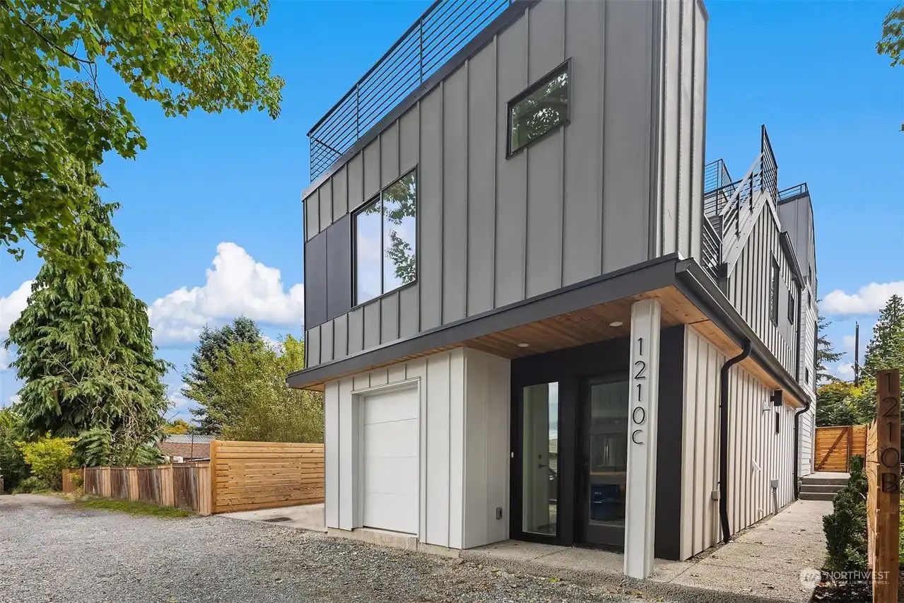 Two-level modern backyard home with board-and-batten siding and a garage
