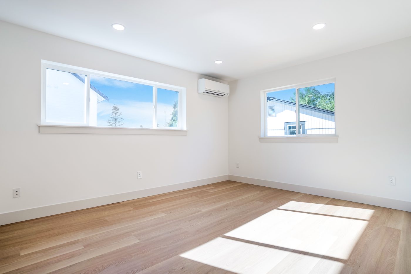 Living area with two windows and oak floors