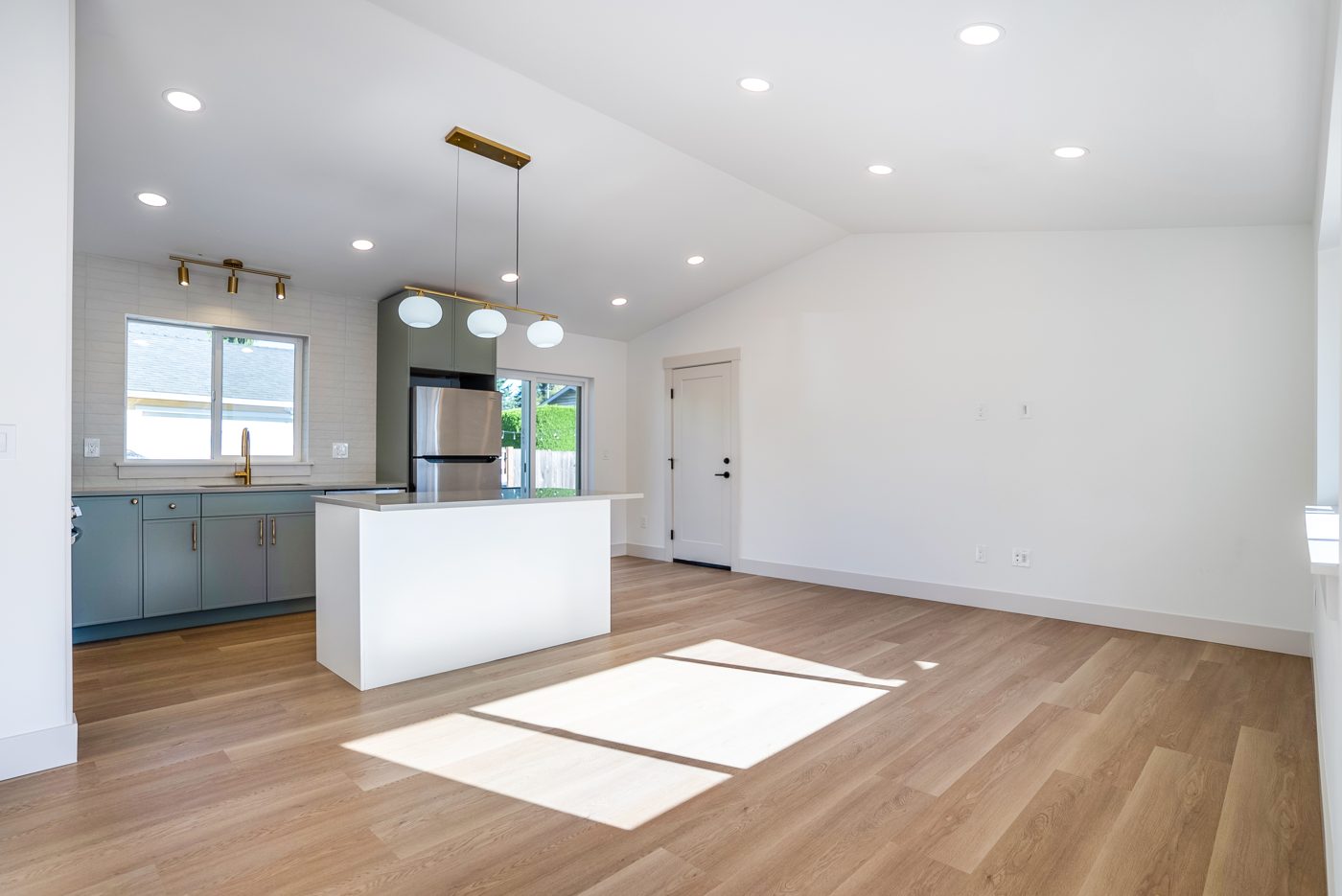 Vaulted great room with the kitchen island and oak floors